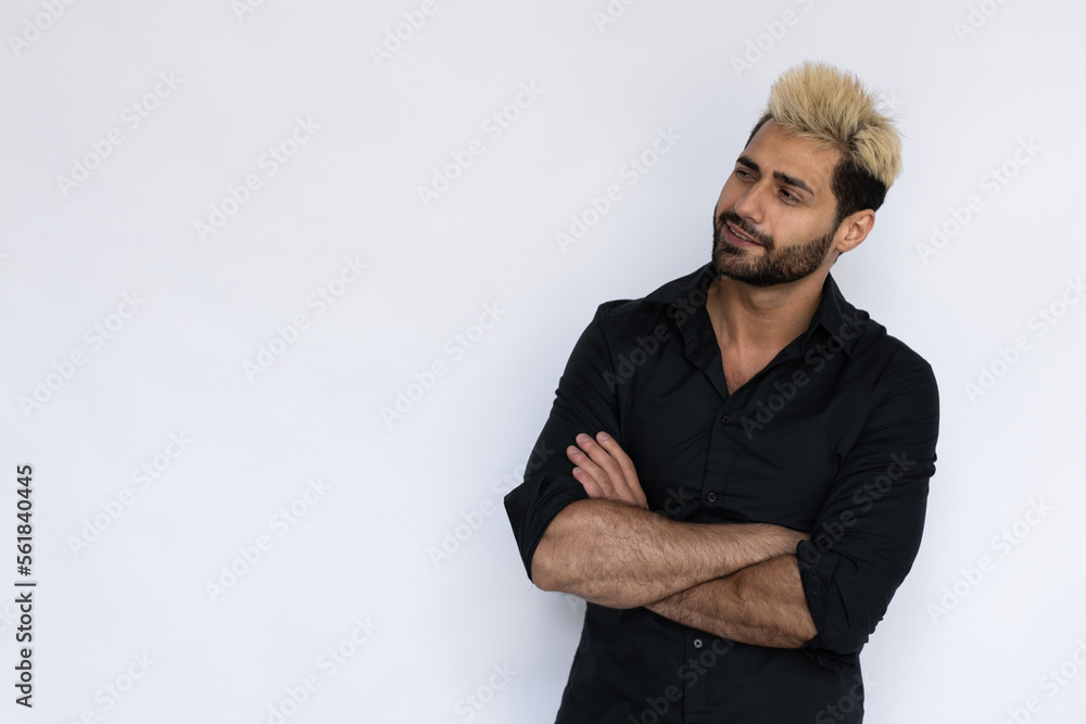 Excited young man looking at copyspace. Male Caucasian model with brown eyes, ombre painted hair and beard in black shirt crossing his hand looking aside. Advertisement concept Excited young man looking at copyspace. Male Caucasian model with brown eyes, ombre painted hair and beard in black shirt crossing his hand looking aside. Advertisement concept