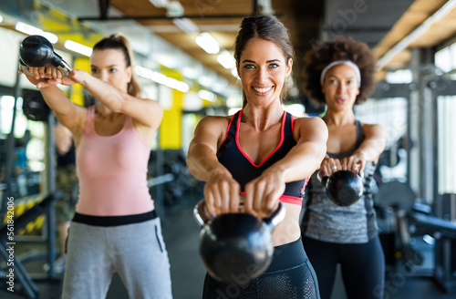 Group of fit people lifting dumbbells during an exercise class at the gym photo