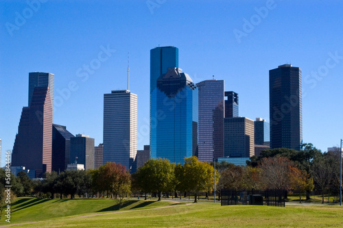 Modern buildings in the Skyline district of downtown Houston, Texas taken across a park with trees © Wildwatertv