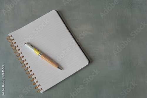 Cahier ouvert sur une page blanche avec un stylo photo