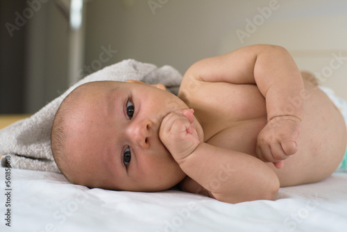 Newborn baby lifting his head on the bed
