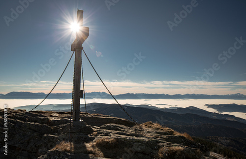 cross at kleiner sauofen at Saualm in the carinthian alps and the sun just behind it.