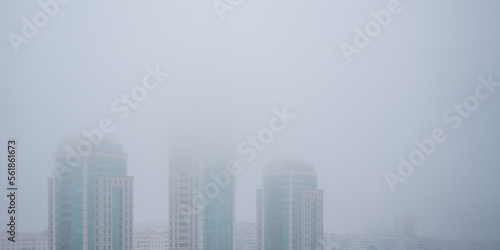 Aerial view to urban buildings covered with thick fog.