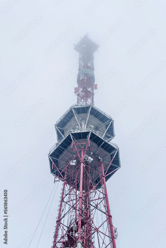 Telecommunications tower in the fog. Cellular communication and the Internet. Bottom view. Vertical.