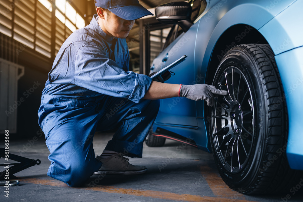 Fototapeta premium Maintenance worker in garage shop service to customer car via insurance system at garage, Safety vehicle to reduce accidents before a long travel, road trip transportation.