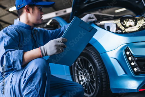 Maintenance worker checking tire service via insurance system at garage, Safety vehicle to reduce accidents before a long travel, road trip transportation.