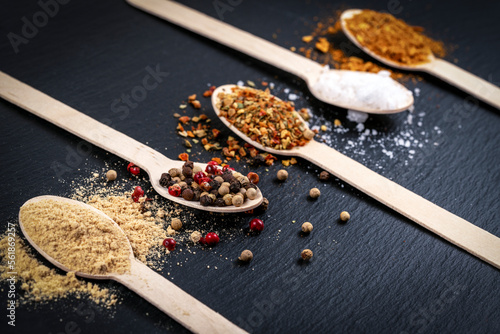 seasonings on spoons on black board