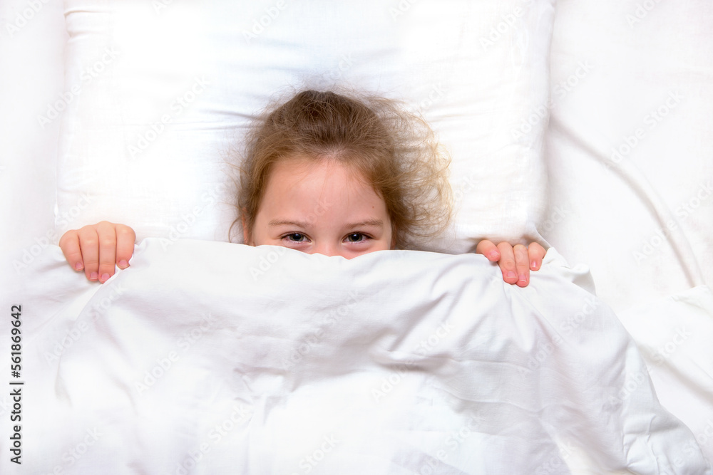 girl with smiling eyes in bed hiding under the covers girl with smiling eyes in bed hiding under the covers