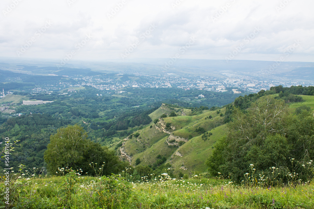 Obraz premium panorama of green hills and valleys in a hazy haze on the horizon in Kislovodsk on a cloudy summer day and space for copying