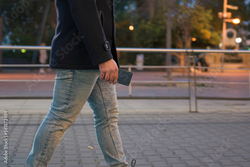 Close-up of a man holding a phone on the street