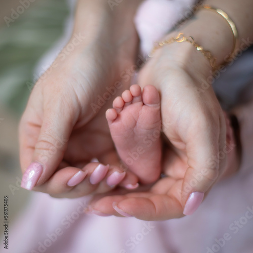 Petit pied de bébé nouveau-né dans les mains de sa maman. qui prend soin de son nourrisson avec amour.