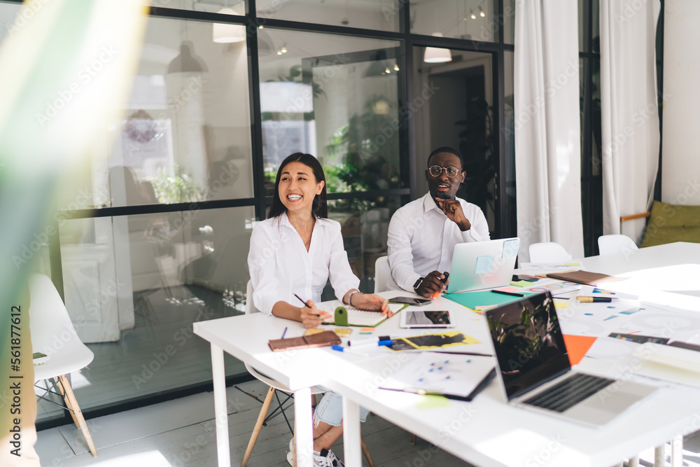 Diverse colleagues working in modern conference room and laughing Diverse colleagues working in modern conference room and laughing