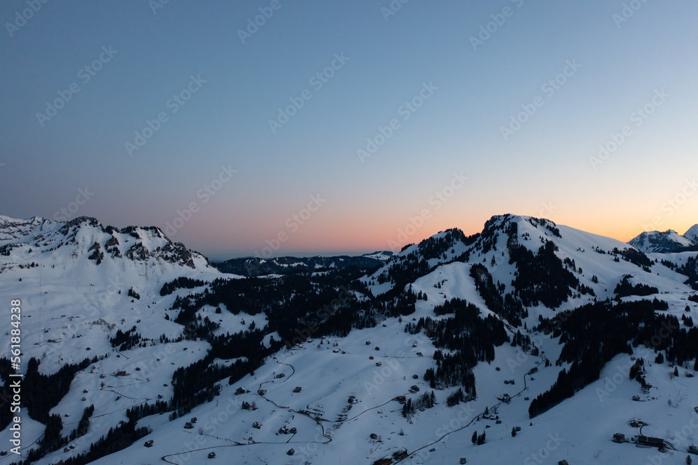 Great drone photo over the Swiss Alps at an epic sunrise with a pink horizon.