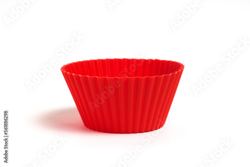 Red silicone mold for baking cupcakes on a white background