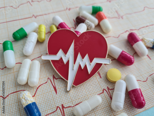 Cardiogram with red heart pills and cardiogram. Treatment of cardiovascular disea photo