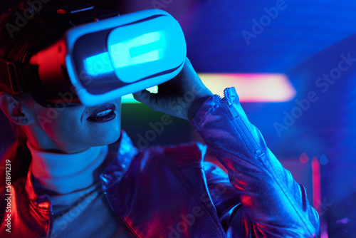 modern woman in virtual reality goggles on dark background