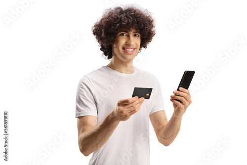 Casual young man with curly hair with a credit card and a smartphone
