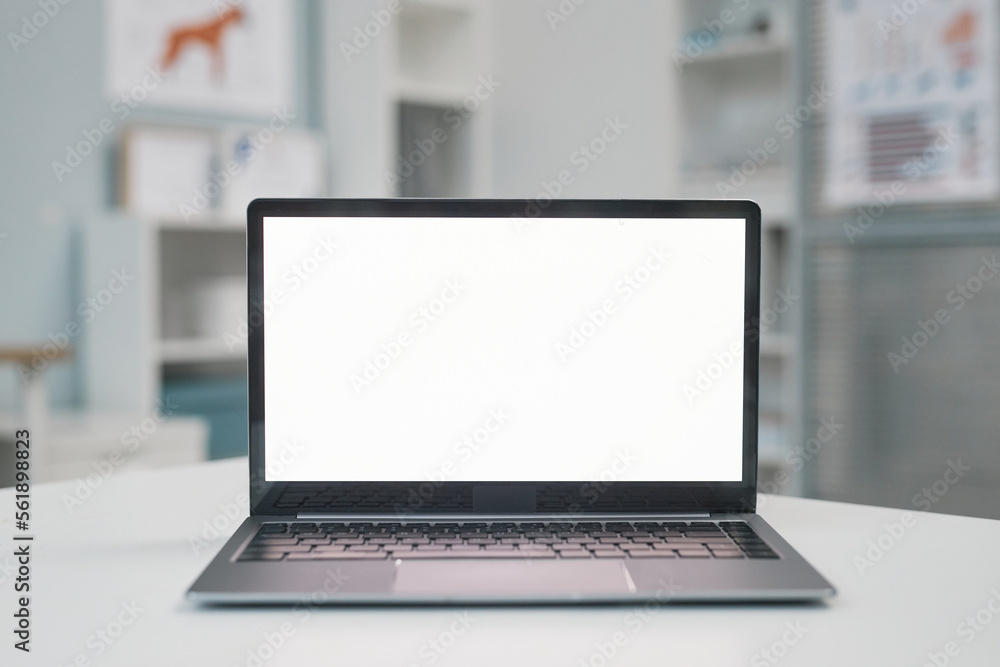Blank screen of laptop on workplace of modern veterinarian Blank screen of laptop on workplace of modern veterinarian