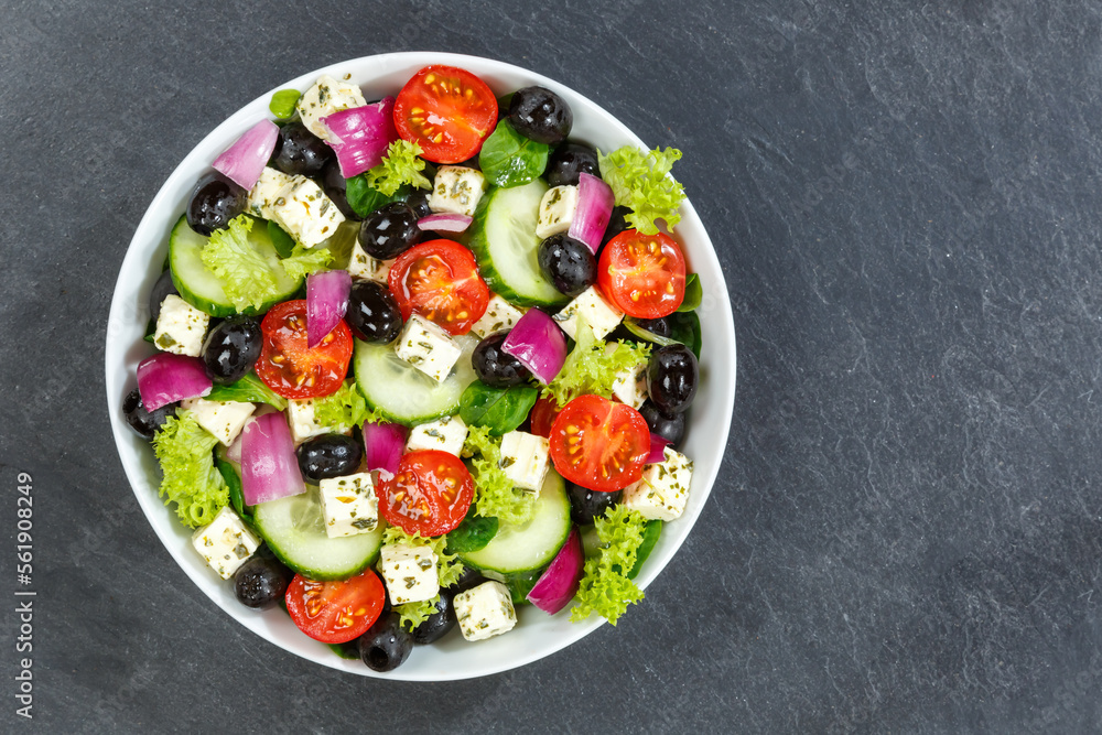 Greek salad with fresh tomatoes olives and feta cheese healthy eating food from above on a slate with copyspace copy space Greek salad with fresh tomatoes olives and feta cheese healthy eating food from above on a slate with copyspace copy space