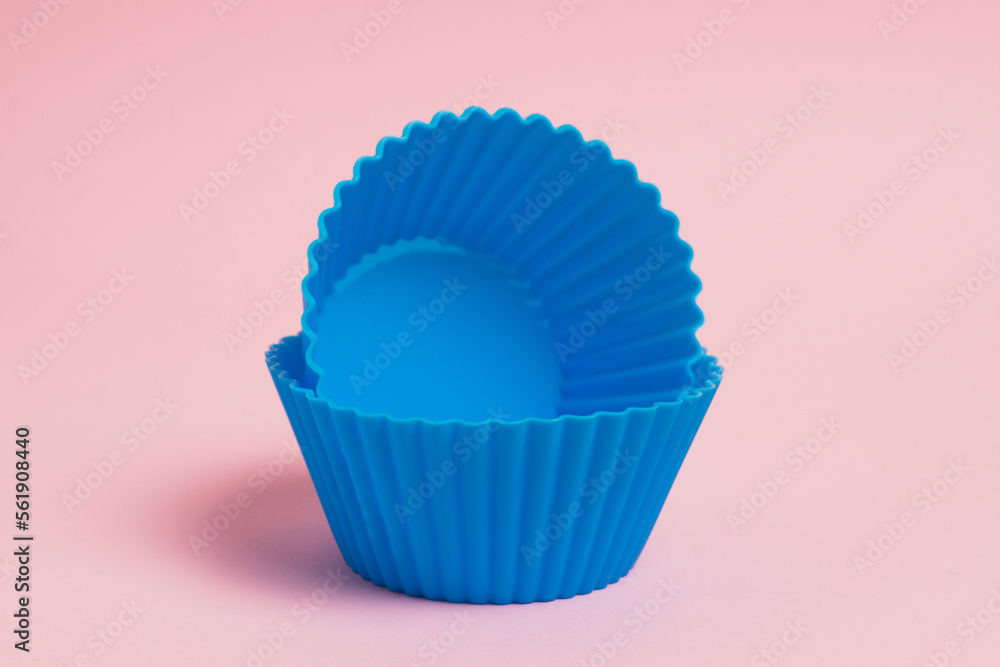 Blue silicone molds for cupcakes on a pink paper background Blue silicone molds for cupcakes on a pink paper background