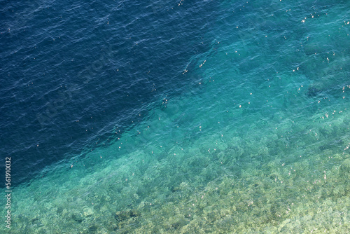 Fototapeta Naklejka Na Ścianę i Meble -  Azure water texture, transparent sea surface with a rocky bottom. Aerial view, natural turquoise background