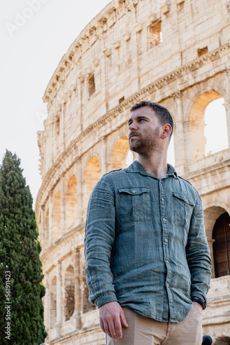 man posing in front of the coliseum