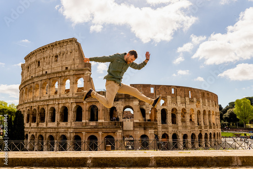 tourist on vacation in rome jumping happy in front of the roman colosseum