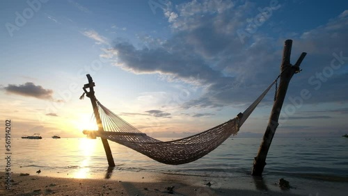 Wide angle video shot of a hammock net installed on the shallow sandy beach on Le Morne peninsula, Mauritius. Calm sunset time 4k footage.