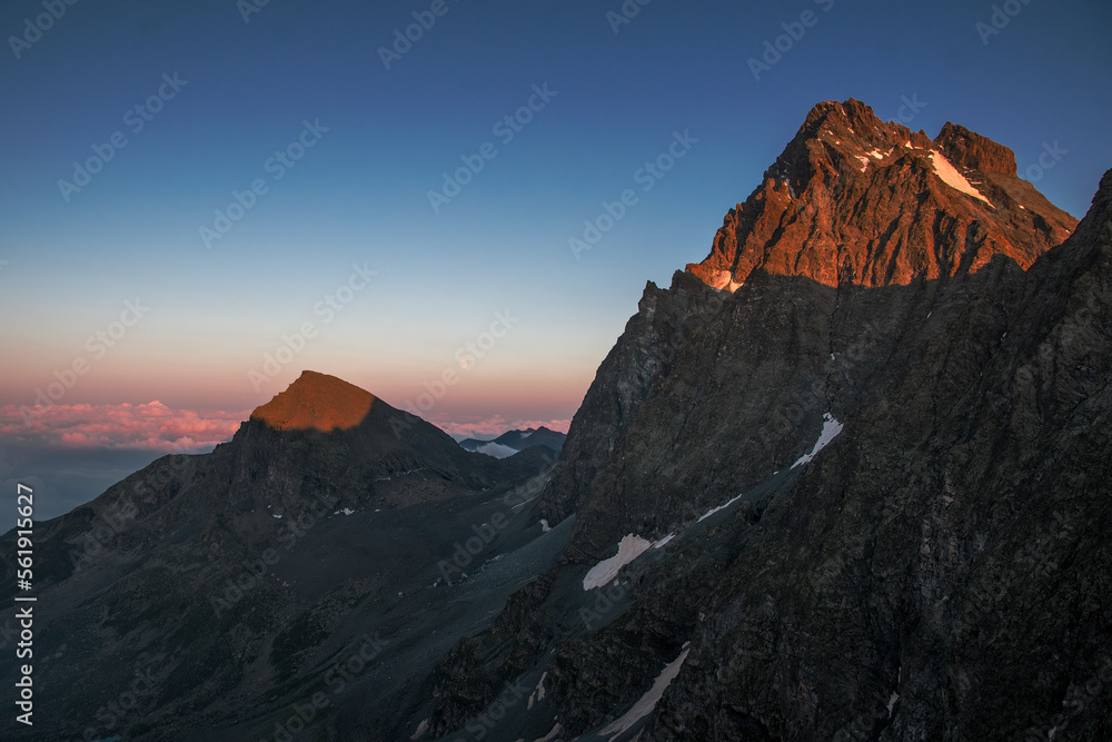 Monviso (3841 meters) and Viso Mozzo, the highest mountains in the Western Alps stands out at sunset while the moon rises on the horizon. Italian Alps, Monviso natural park.