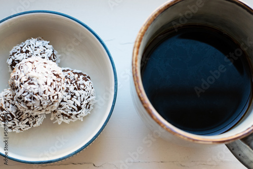 View from above of cup of black coffee and a plate with homemade raw chocolate balls, which is a classic no bake pastry in Sweden and Denmark.