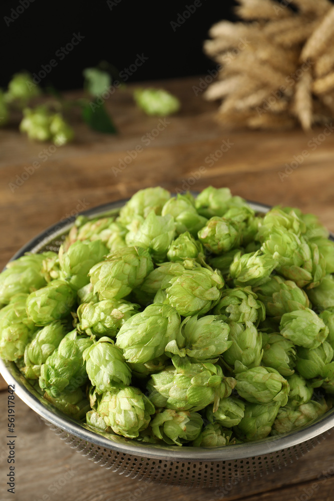 Fresh green hops in sieve on wooden table, closeup Fresh green hops in sieve on wooden table, closeup