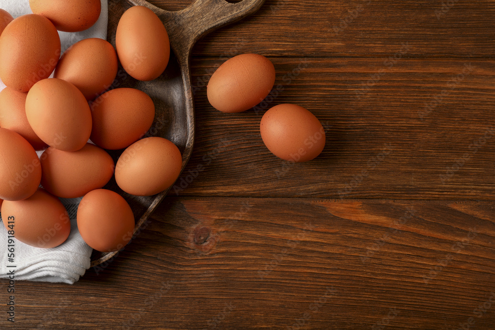 Raw brown chicken eggs on wooden table, flat lay. Space for text Raw brown chicken eggs on wooden table, flat lay. Space for text