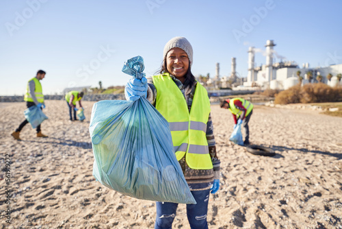 фотографія Young latin activist looking at camera holding a garbage bag trash