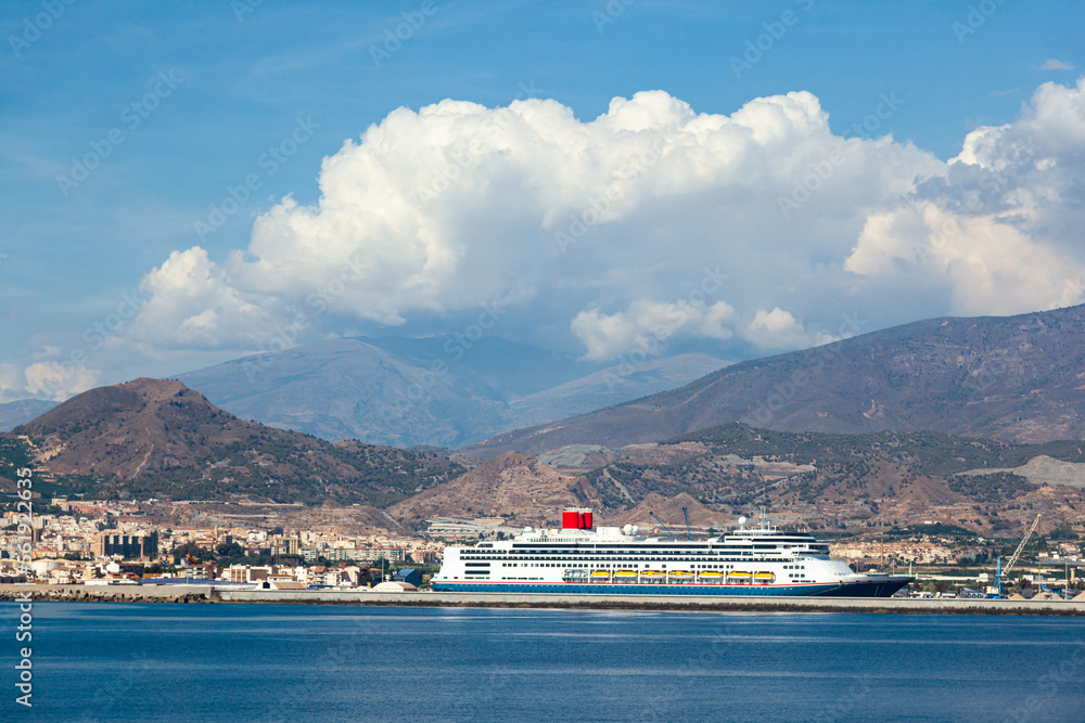 Cruise passenger ship moored in the Spanish seaport of Mortil against the backdrop of the mountains.