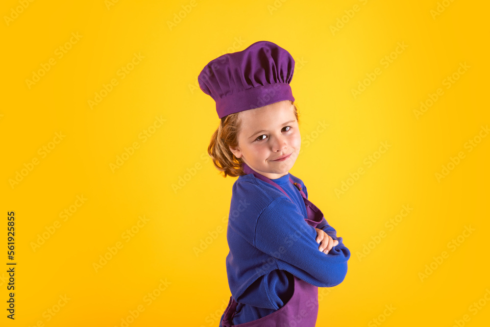 Kid in cooker uniform and chef hat preparing food on studio color background. Cooking, culinary and kids food concept. Kid in cooker uniform and chef hat preparing food on studio color background. Cooking, culinary and kids food concept.
