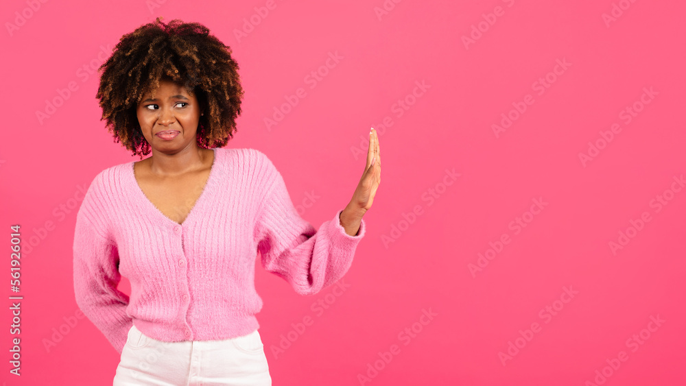 Sad confused millennial african american curly woman in casual show hand stop sign, isolated on pink background Sad confused millennial african american curly woman in casual show hand stop sign, isolated on pink background