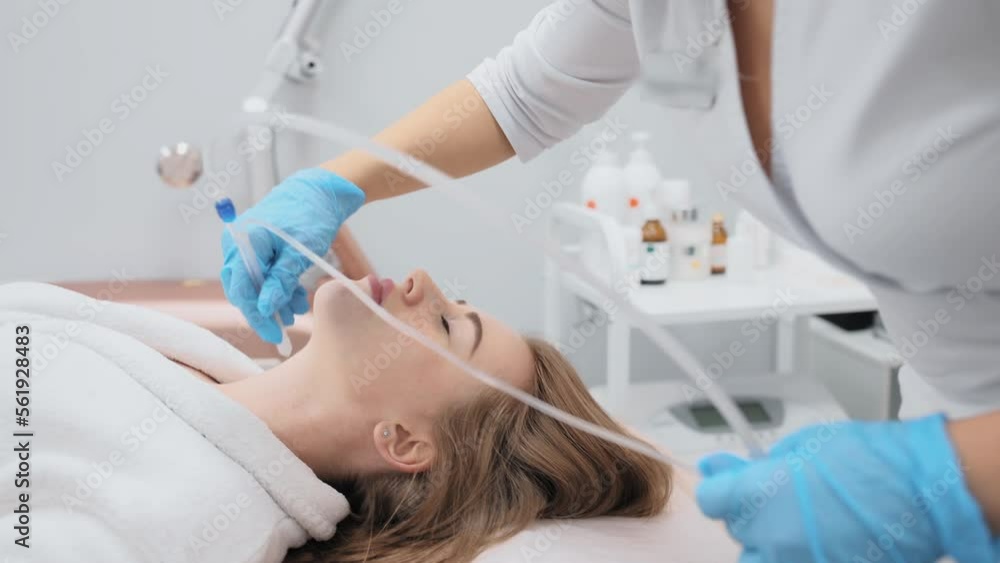 cosmetologist performs a gas-liquid peeling procedure - rejuvenation and regeneration of the skin using a jet consisting of oxygen and liquid. cosmetologist performs a gas-liquid peeling procedure - rejuvenation and regeneration of the skin using a jet consisting of oxygen and liquid.