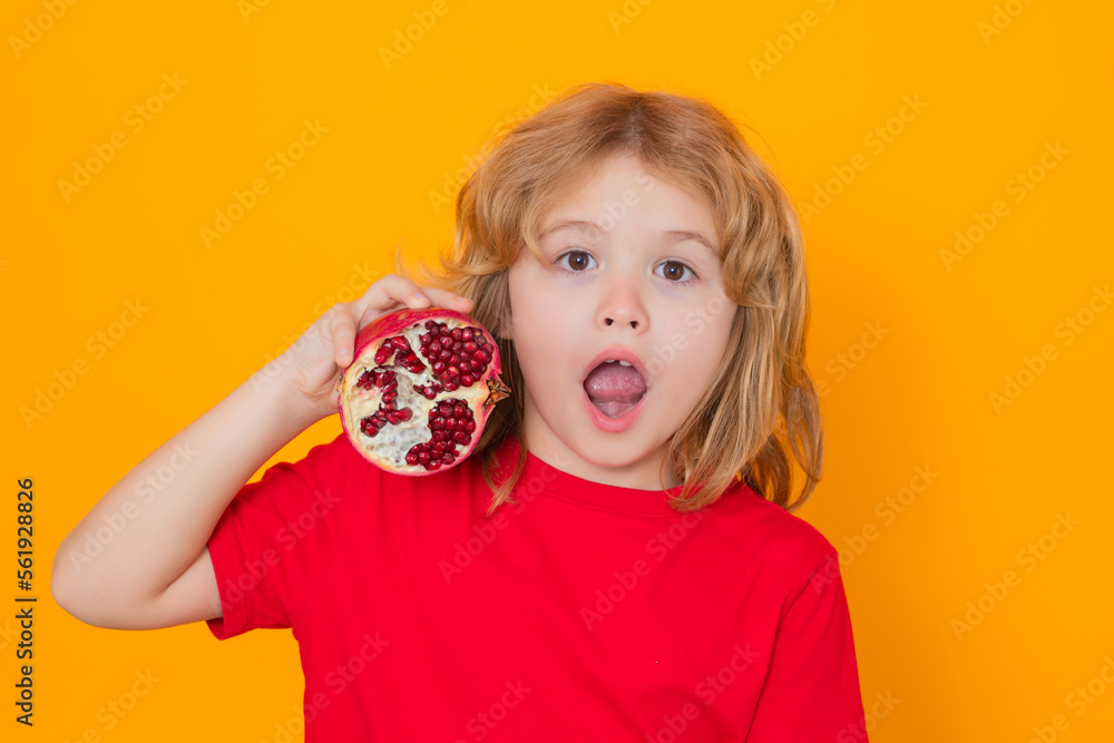 Pomegranate. Kid hold red pomegranate in studio. Studio portrait of cute child with pomegranate isolated on yellow background with copy space. Pomegranate. Kid hold red pomegranate in studio. Studio portrait of cute child with pomegranate isolated on yellow background with copy space.