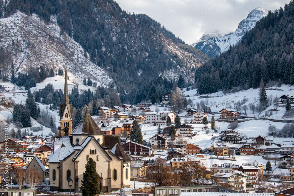 Fresh morning snow in Dolomites behind the Church of San Vigilio and other village buildings, Moena, Italy, January 2023