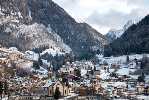 Moena, Italy, January 16th 2023. Fresh morning snow in Dolomites behind the Church of San Vigilio and other village buildings.