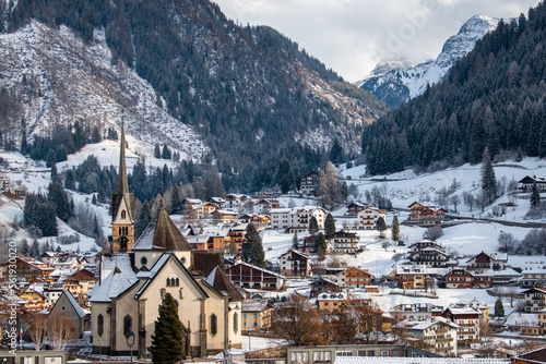 Fresh morning snow in Dolomites behind the Church of San Vigilio and other village buildings, Moena, Italy, January 2023