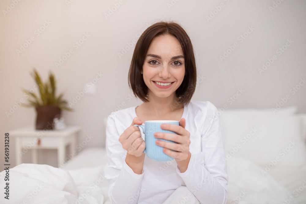 Positive young lady enjoying fresh morning coffee at home Positive young lady enjoying fresh morning coffee at home
