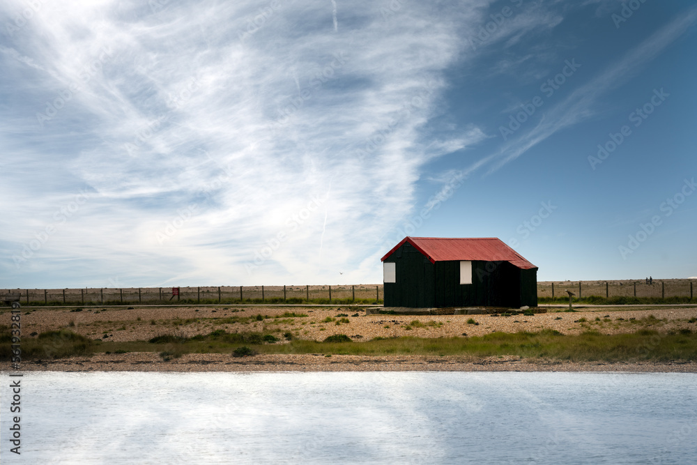 Red roof fishing hut in Rye Harbour Nature Reserve. East Sussex, England