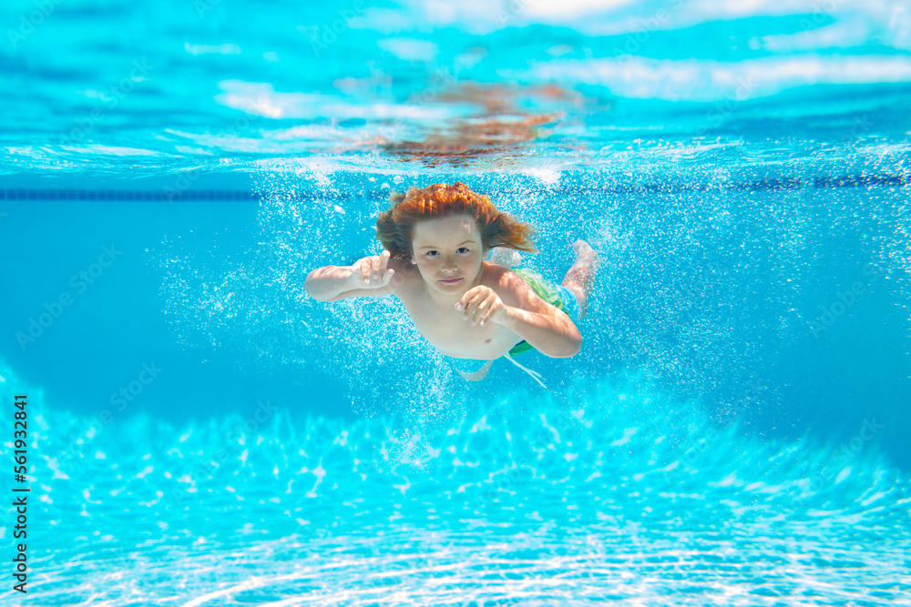 Kid swimming underwater on the beach on sea in summer. Blue ocean water. Child boy swimming in sea.