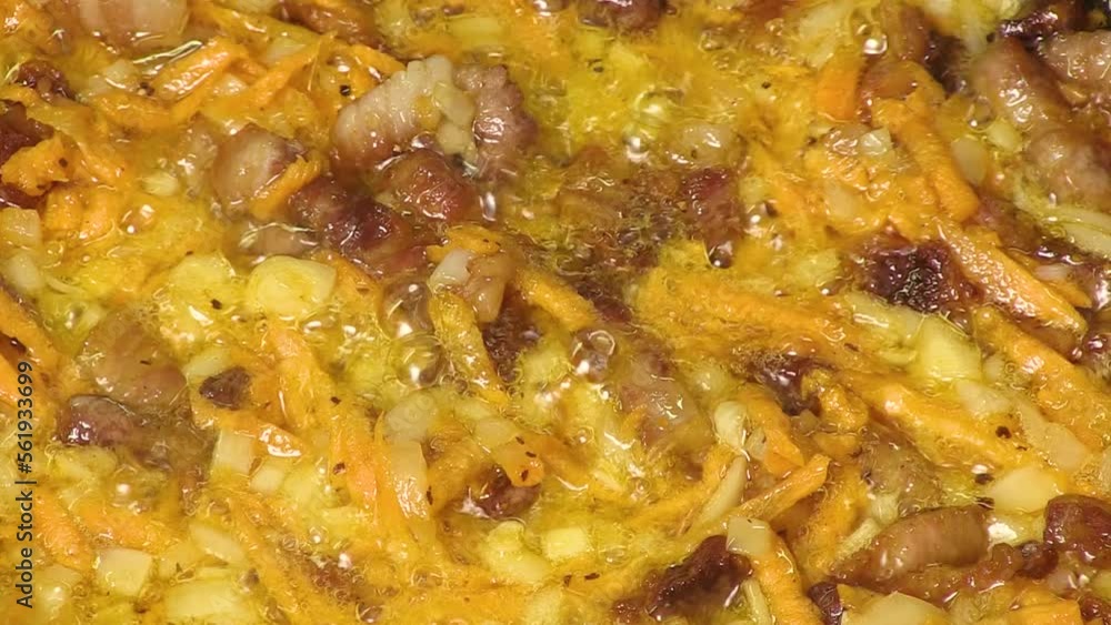 Meat and vegetables are fried in a pan with vegetables. The chef's hand stirs the ingredients. Close-up video Meat and vegetables are fried in a pan with vegetables. The chef's hand stirs the ingredients. Close-up video