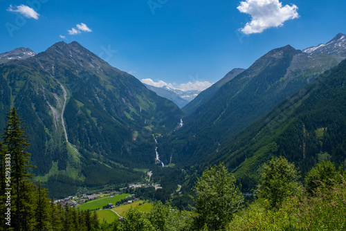 Panoramic view of idyllic mountain scenery in the Alps with fresh green meadows in bloom on a beautiful sunny day in springtime