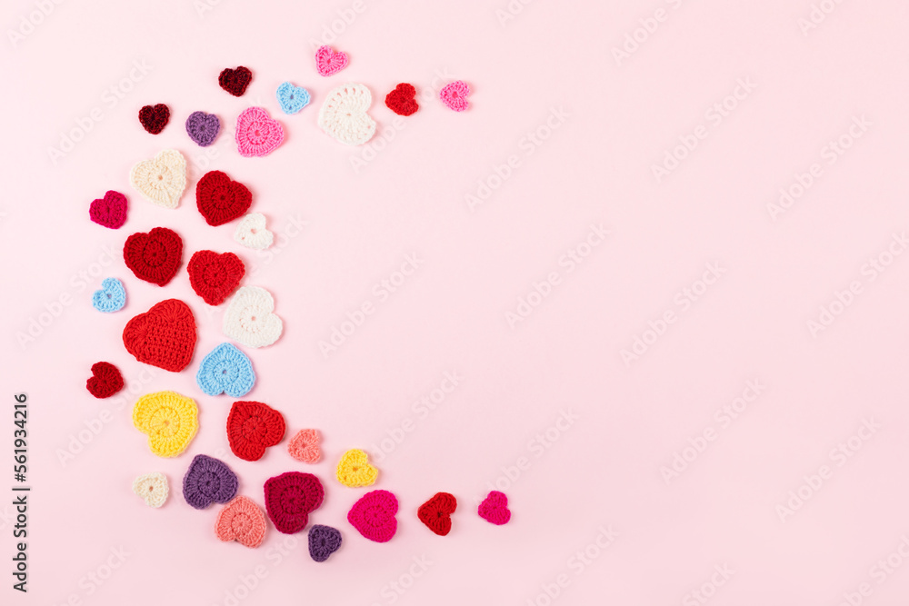 Multicolored crocheted hearts are laid out in the shape of the moon on a lilac background. Happy Valentine's Day, Mother's Day and birthday greeting card.