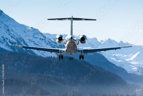 Fototapeta Naklejka Na Ścianę i Meble -  Luxurious business jet landing in the Swiss alps. Airplanes like this are the way to travel to the witner resort of St. Moritz for successful business people