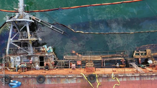 Top view drowned sunken tanker ship in the shallow water. Aerial top view of overturned broken rusty old ship.