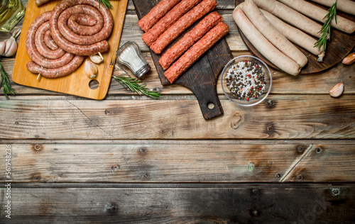 Different types of raw sausages with seasonings and herbs.